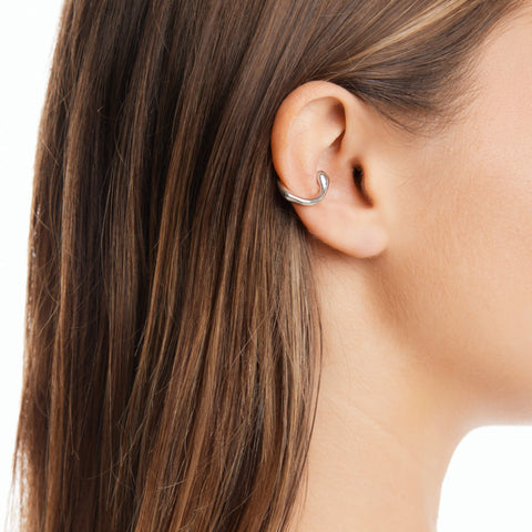 "Dusk women's ear cuff by Five Jwlry, part of Alicia Moffet's collaboration. This organically shaped piece elegantly wraps around the ear, requiring no piercing. Available in 14k gold or silver, crafted from water-resistant 316L stainless steel. Hypoallergenic with a 2-year warranty.