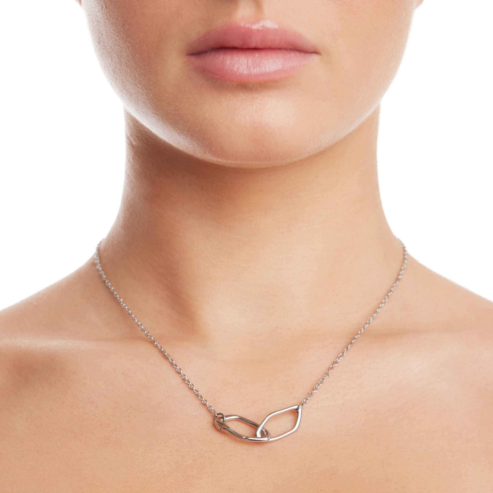 Dusk women's necklace by Five Jwlry, part of Alicia Moffet's collaboration. The necklace showcases a pendant with two organically crisscrossed hoops, cleverly incorporating the clasp. Paired with a fine 2mm cable chain, available in 14k gold or silver, crafted from water-resistant 316L stainless steel. Hypoallergenic with a 2-year warranty.